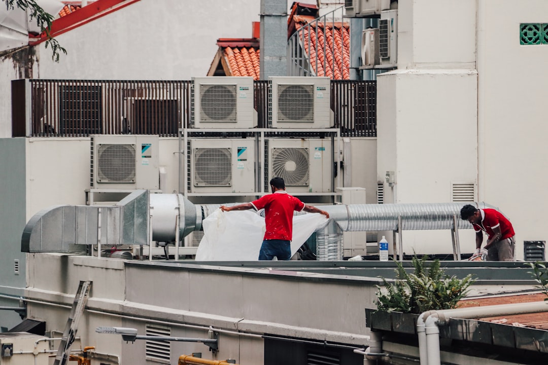 Technicien effectuant l'entretien d'une unité intérieure de climatisation
